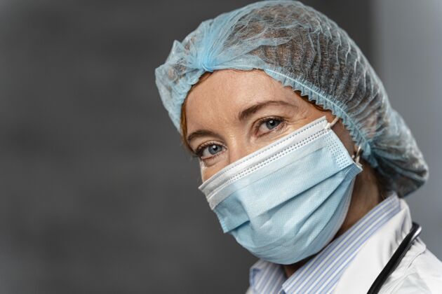 工作带着医用口罩和带复印空间的发网的女医生临床医生职业医学