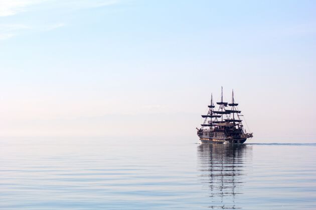 旧一艘高大的船在白天在美丽的清水上航行的水平镜头航海船地平线