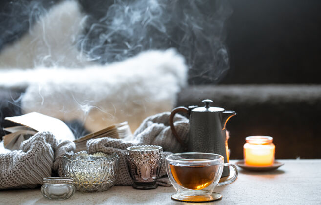 装饰一杯茶 一个茶壶和美丽的老式烛台 背景模糊的蜡烛 静物画构图杯子茶
