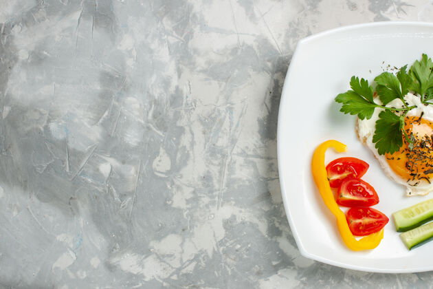 西红柿顶视图板上有蔬菜和蔬菜的食物 浅白的桌子上有蔬菜食物午餐的彩色照片盘子背景生的