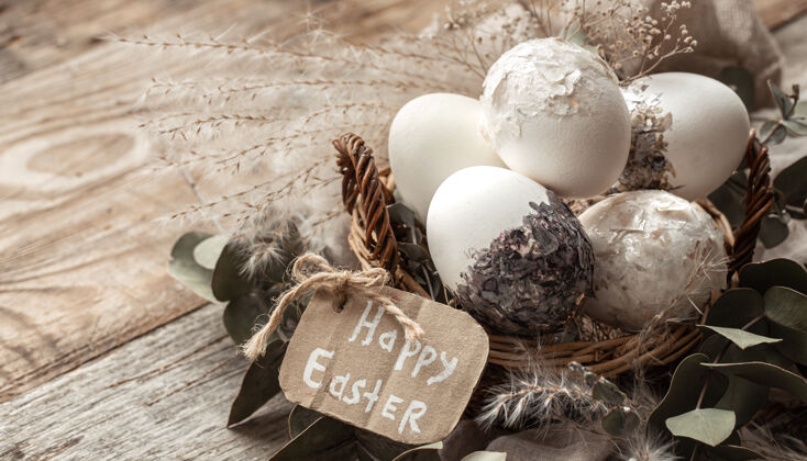 符号漂亮的复活节彩蛋放在一个用干花装饰的篮子里复活节快乐复活节传统愿望