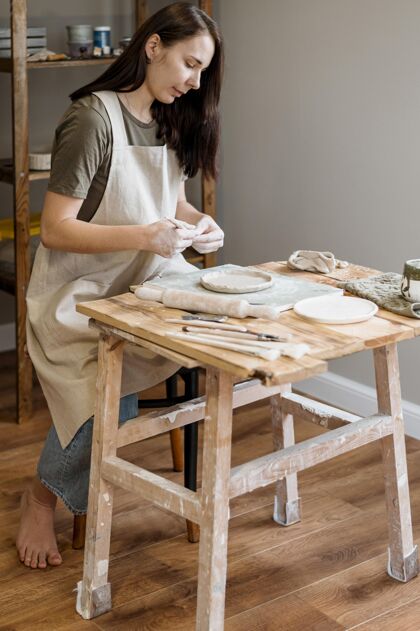 陶器有创意的女人在她的工作室里做一个陶罐工匠陶瓷陶工