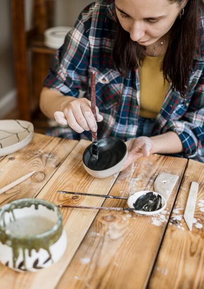 艺术家做陶器杰作的女人手工工作场所粘土