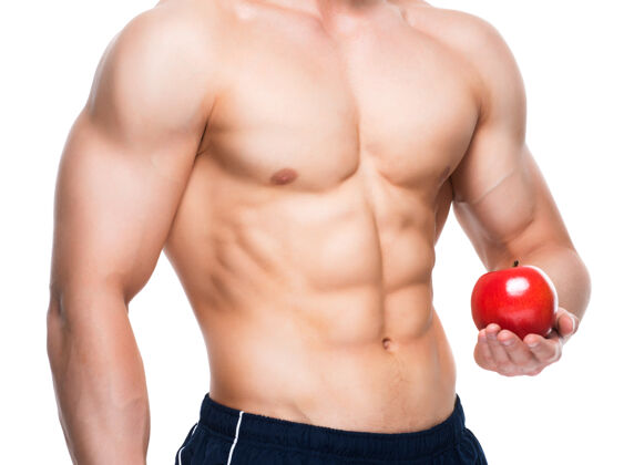 成人身材完美的年轻人手里拿着红苹果胸部肌肉健美