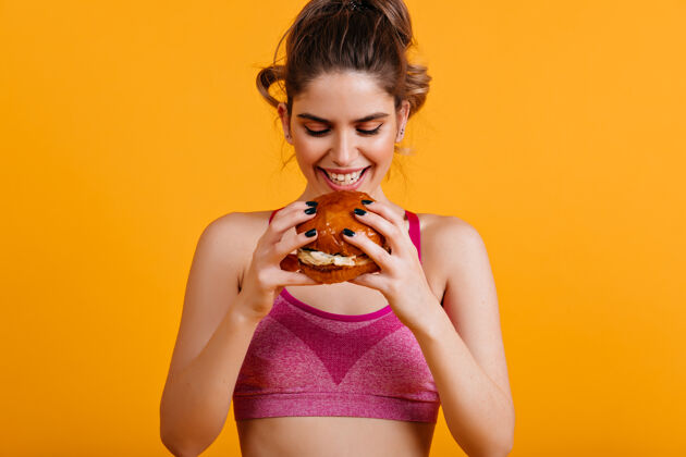 汉堡包微笑的女人吃汉堡面子运动年轻女人