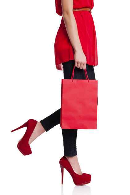 时尚穿着红色高跟鞋拿着红色购物袋的女人低角度视图低段步行