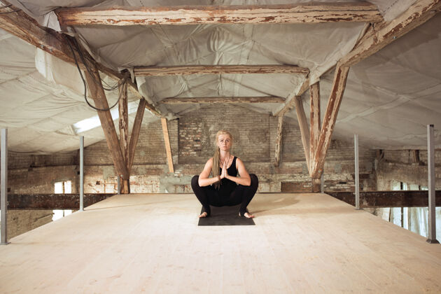 锻炼力量一个年轻的女运动员在废弃的建筑上练习瑜伽心理和身体健康平衡健活方式的概念 运动 活动 减肥 专注建筑城市人类