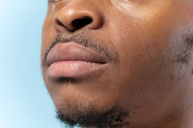 人在蓝色背景上的非洲裔年轻人的特写肖像人类的情感 面部表情 广告 销售或男人的美丽和健康概念嘴唇的照片看起来很平静顺序人衬衫