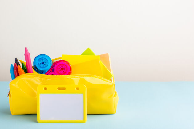 彩色正面图蓝色书桌上的黄色笔盒内有不同颜色的铅笔记事本钢笔容器