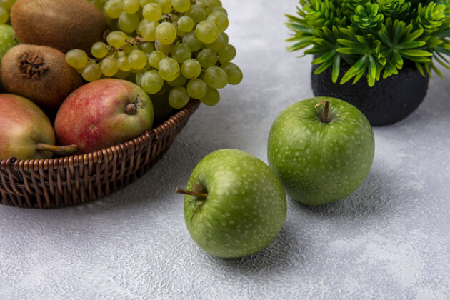 正面正面图绿色的苹果和梨绿色的葡萄和猕猴桃在一个篮子在白色的背景篮子景观苹果