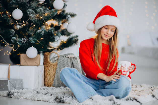 圣诞老人在圣诞树旁喝可可的女孩圣诞快乐房子红毛衣