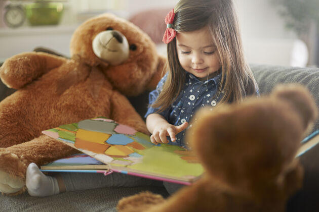 阅读小女孩和她的泰迪熊一起看书成长童年女孩