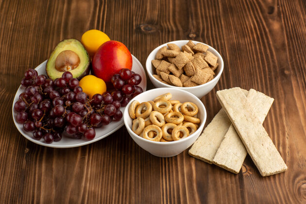 胡椒在棕色的木制书桌上可以看到不同的水果和饼干膳食健康饼干