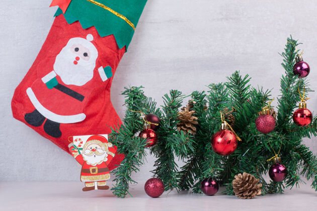 灯白色表面上满是节日球的圣诞袜装饰品圣诞老人袜子