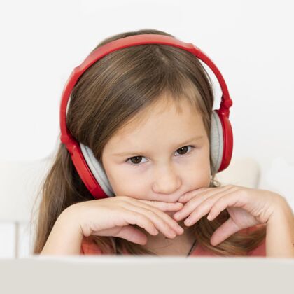 业余爱好戴着耳机的小女孩的前视图耳机设备科技