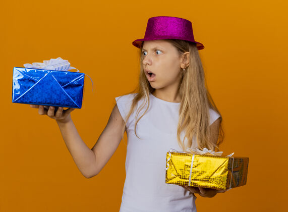 小戴着节日帽子拿着礼品盒的漂亮小女孩生日礼物站着