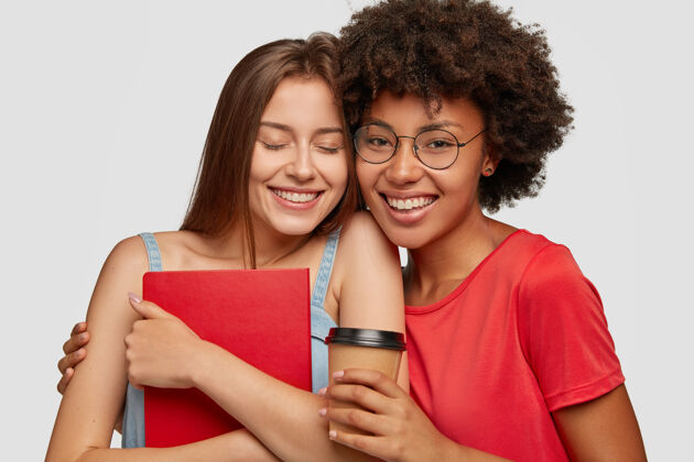 姐妹照片中的混血友好积极的女孩拥抱作为花时间在一起学习学生眨眼群友