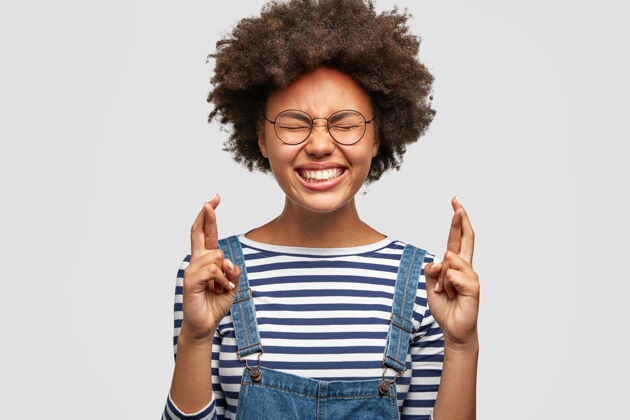 积极喜极而泣的黑皮肤女人的剪影在期待考试结果时交叉手指外表学生毛衣