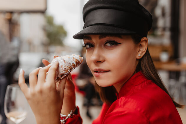 腰带黑发女孩看到糖霜面包咬嘴唇时尚博客在法国旅行的特写写真空气之吻法国巴黎