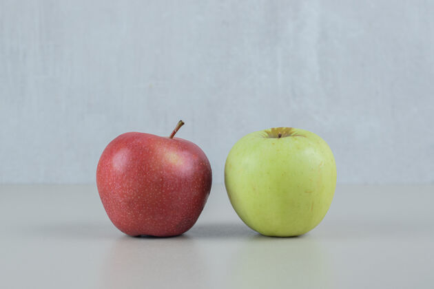 绿色红绿色的新鲜苹果挂在灰色的墙上素食营养异国情调