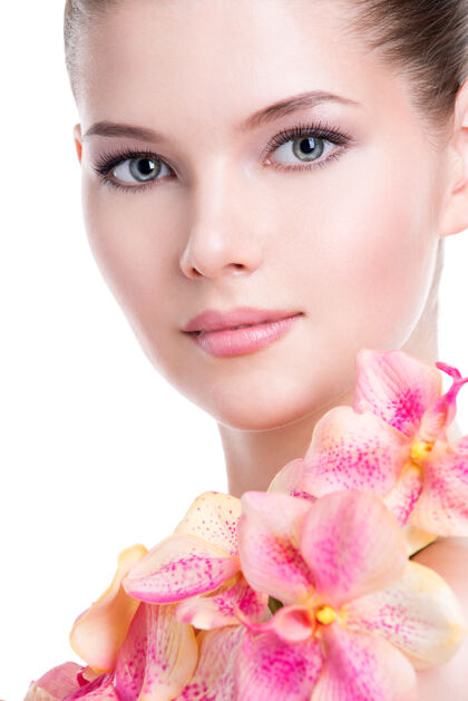年轻美丽的年轻女子的特写肖像 健康的皮肤和粉红色的花朵在身体上-隔离在白色上女性漂亮皮肤护理