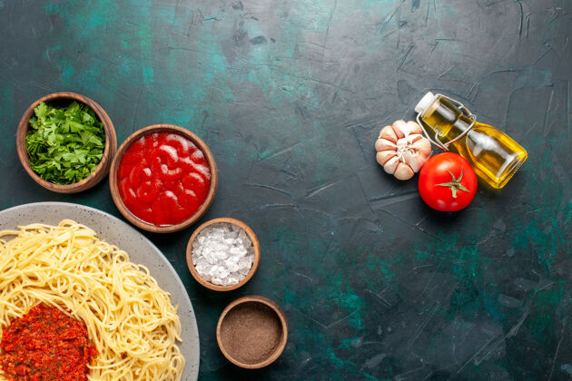 意大利俯瞰煮熟的意大利面食 蓝色表面有肉和不同的调味品不同意大利面季节
