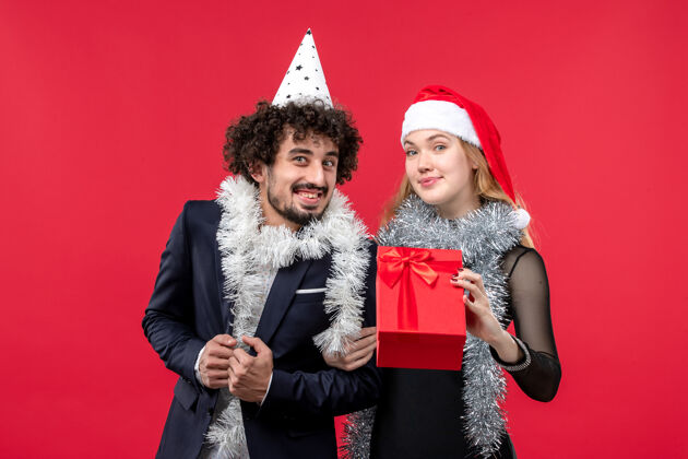 风景红桌圣诞爱情长假 年轻夫妇带着新年礼物前视图肖像服装圣诞节