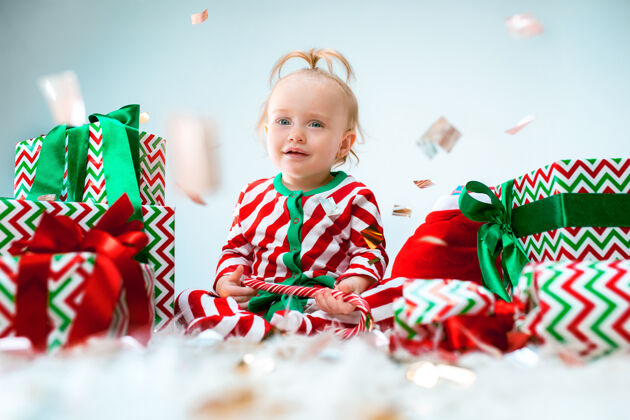房间可爱的女婴1岁左右的圣诞老人帽子摆姿势惊讶礼物灯