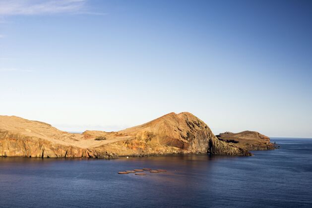 辉光阳光下岩石环绕的大海和葡萄牙白天的蓝天岩石天空风景