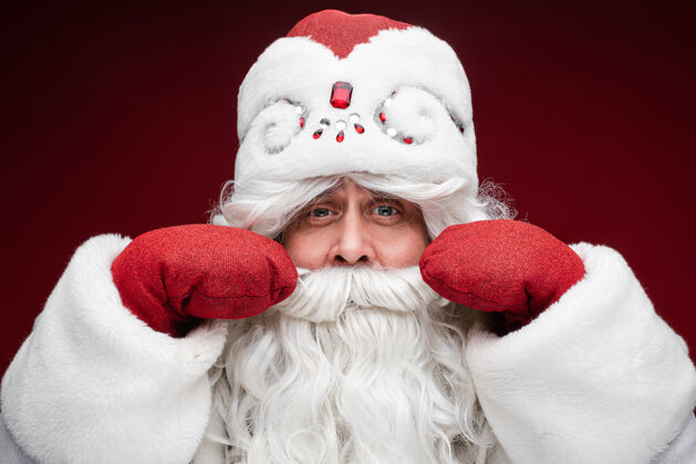 庆祝圣诞老人灰色头发戴手套的高级男性展示他的胡子圣诞节冬天节日