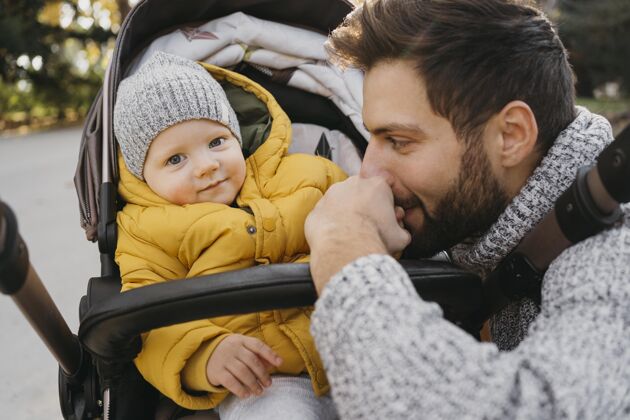 爱爸爸和孩子在外面的婴儿车里大自然家庭孩子团结