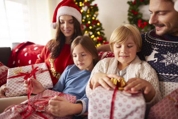 帽子家人在家里打开圣诞礼物孩子圣诞装饰盒子