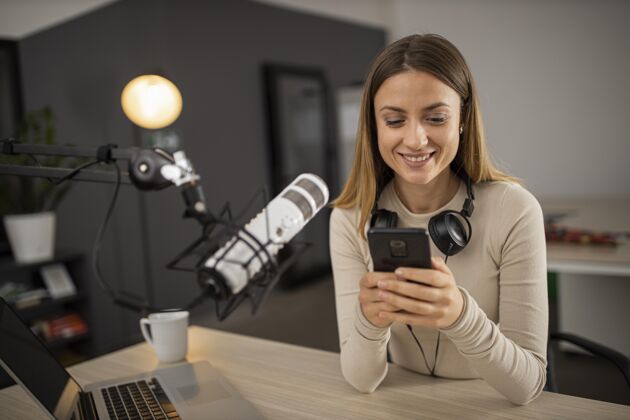 广播笑脸女人用麦克风和智能手机做收音机传输公告水平