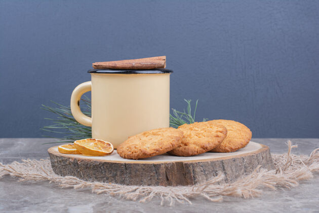 香草一块木板上放着饼干 周围放着一杯茶甜品地壳饮料