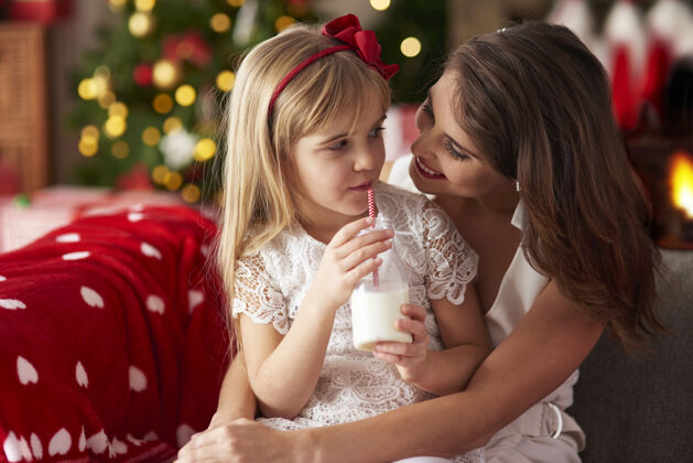 微笑妈妈和女儿在家过圣诞节十二月装饰珠宝