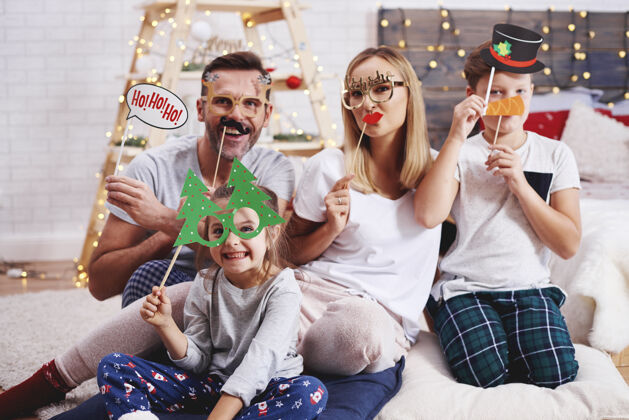 庆祝戴着圣诞面具的幸福家庭的画像微笑灯牙齿