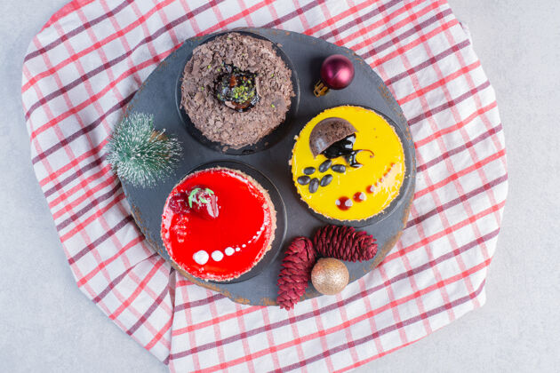 水果各种各样的蛋糕和圣诞装饰品放在深色的木板上甜点面包房蛋糕