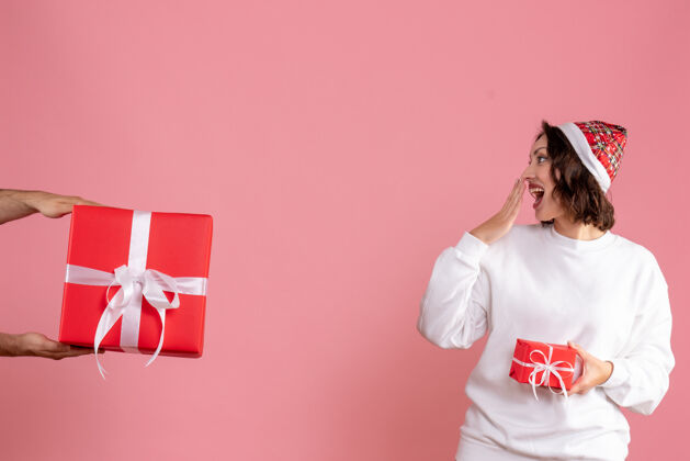 模特年轻女子拿着小礼物 在粉色墙上接受男人的礼物小女性接受