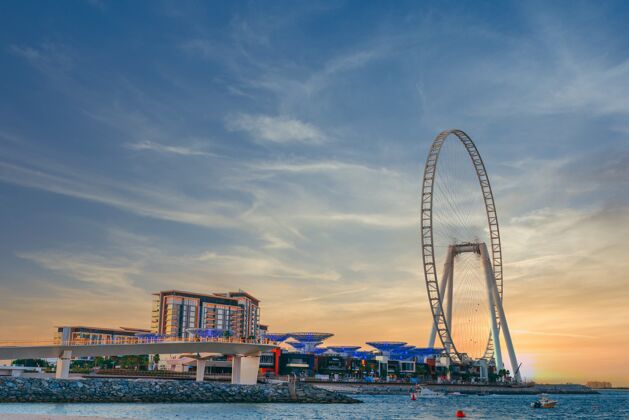 海滩低角度拍摄的现代设计与一个巨大的摩天轮在迪拜的蓝水岛建设景点建筑岛屿