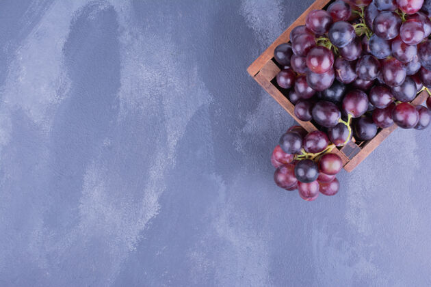 热带一大串红葡萄放在乡下的盘子里浅色扁豆异国情调