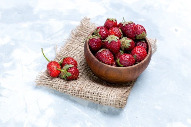 口味正面近距离观看新鲜的红色草莓在棕色的锅里淡白色的书桌上草莓水果新鲜的维生素味道照片维生素农产品生的