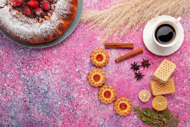 杯子俯瞰美味的草莓蛋糕糖粉蛋糕加华夫饼小饼干和一杯茶放在粉红色的桌子上蛋糕甜甜的糖饼干馅饼蛋糕视野桌子