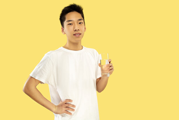 长相韩国年轻人的肖像穿白衬衫的男模饮用水人类情感的概念 面部表情前视图流行的颜色成年人思考亚洲人