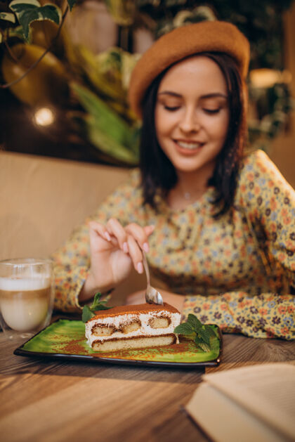 享受在咖啡馆吃美味提拉米苏的年轻女人浪漫传统美食