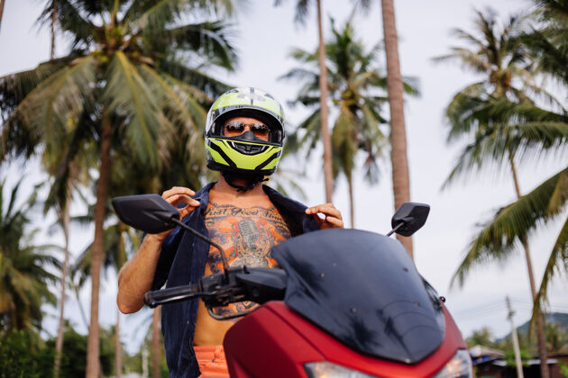 生活在热带丛林的田野上纹着红色摩托车的壮汉手车辆乘坐