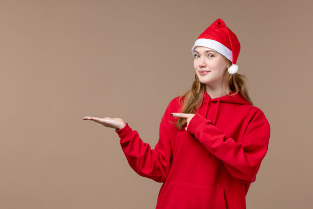 职业正面是棕色空间上穿着红色斗篷的圣诞女孩制服女孩帽子