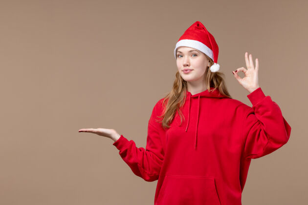 节日正面图圣诞节女孩微笑在棕色背景节日新年圣诞节棕色年份帽子