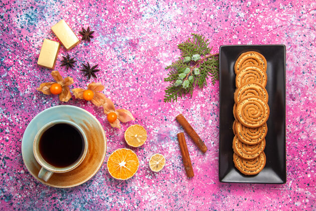 饼干一杯茶 配上饼干和肉桂 放在浅粉色的桌子上饮料饼干糖