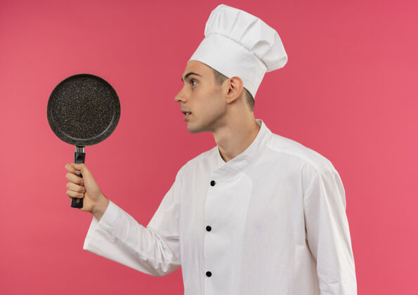 煎着站在剖面图年轻的男厨师穿着厨师制服拿着煎锅男厨师厨师