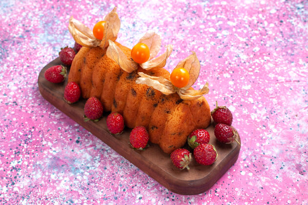 糖在粉红色的桌子上放着美味的蛋糕和新鲜的草莓甜点蛋糕草莓